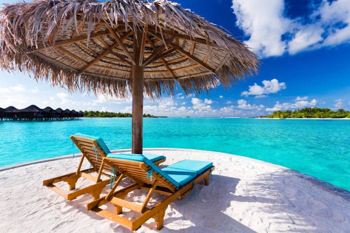 Two chairs and umbrella on stunning tropical beach
